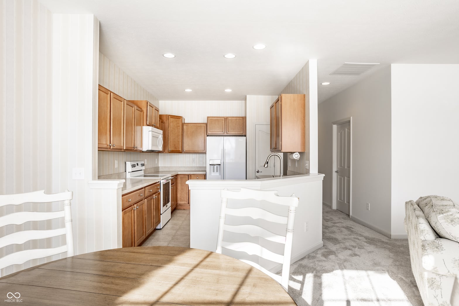 Bright open kitchen with wood cabinets and quartz island.