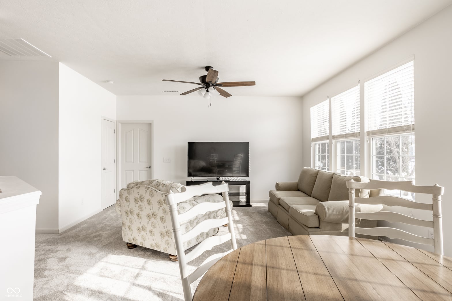 Bright primary suite with sitting area and TV.