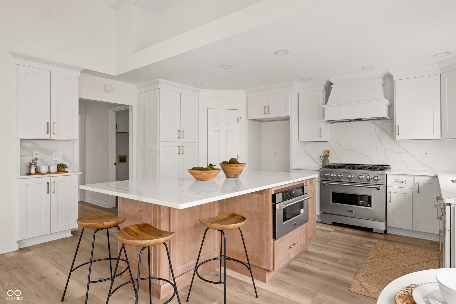 Luxurious two-tone kitchen with marble counters and professional appliances.