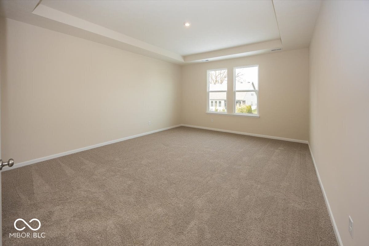 Bright bedroom with modern tray ceiling and natural light.