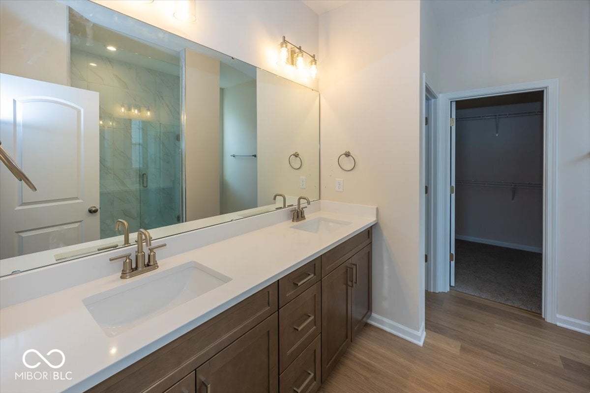 Luxurious primary bath with double vanity and frameless shower.