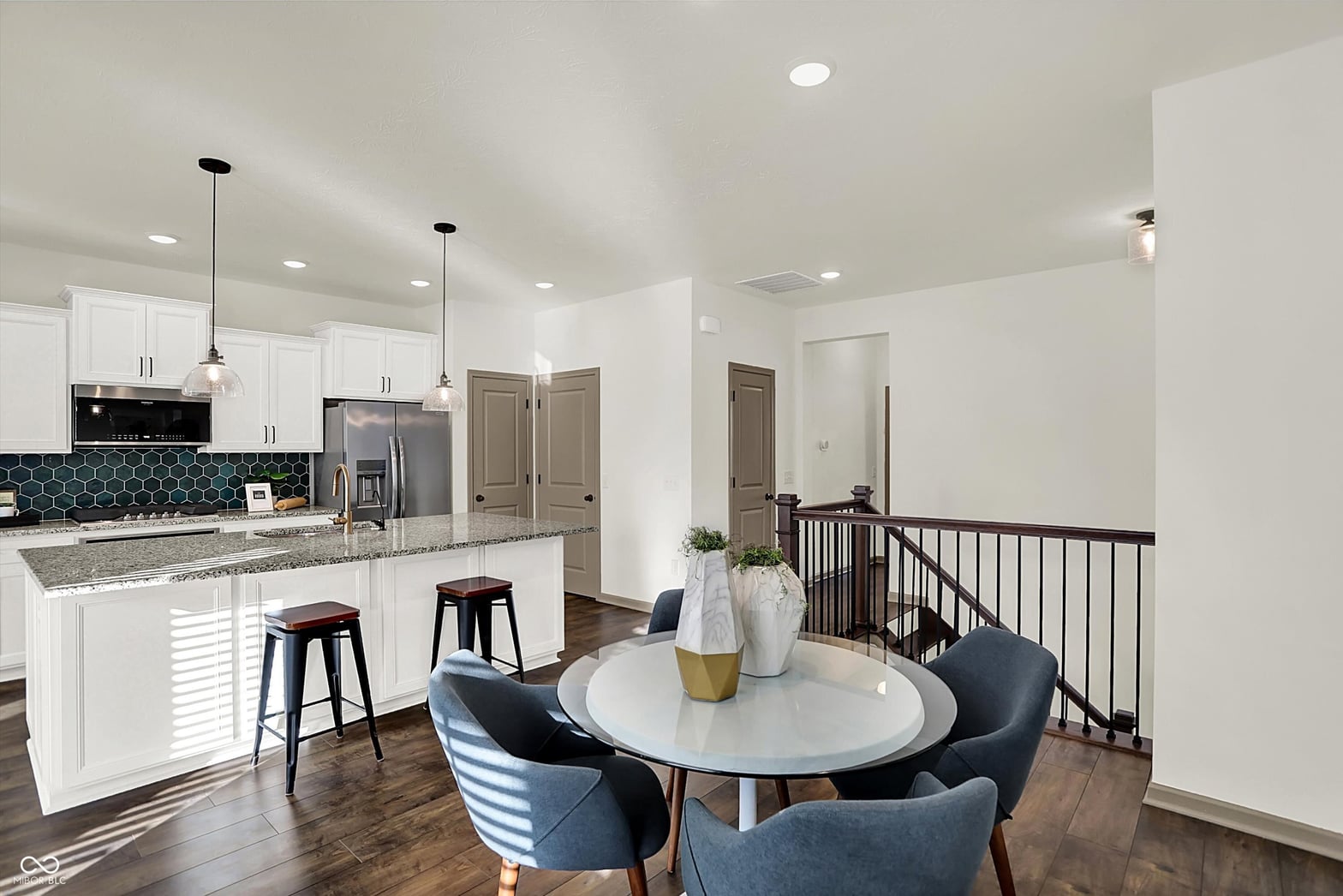 Bright modern kitchen with granite counters and white cabinetry.