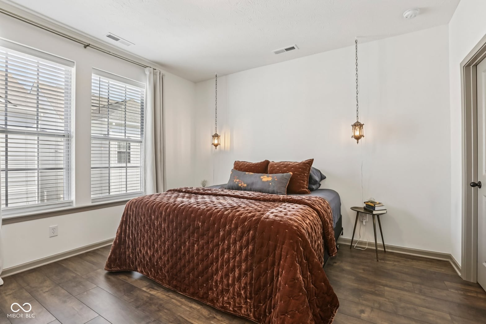 Bright primary bedroom with abundant natural light and modern finishes.