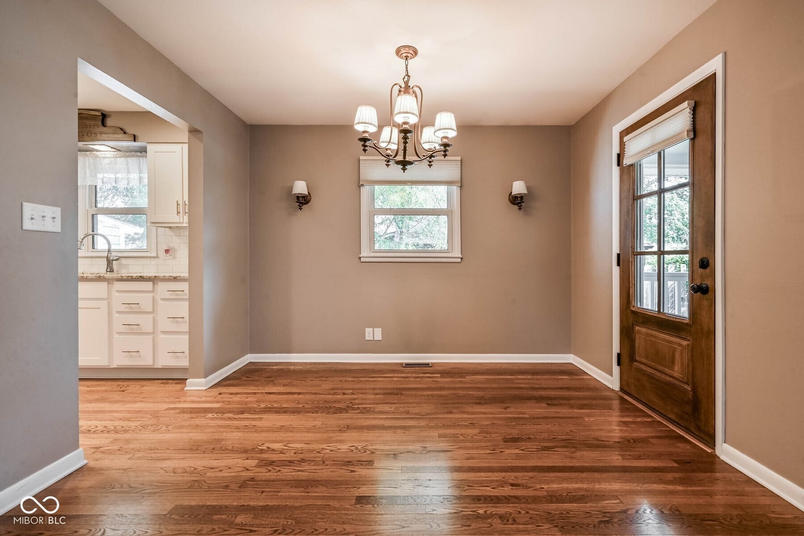 Bright dining room with hardwood floors and elegant fixtures.