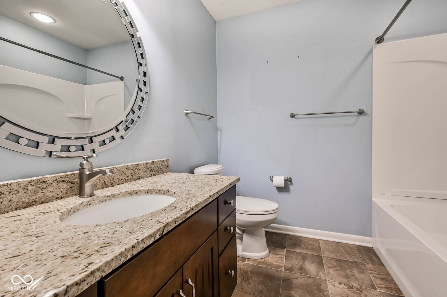 Spacious primary bath with granite counters and double vanity.