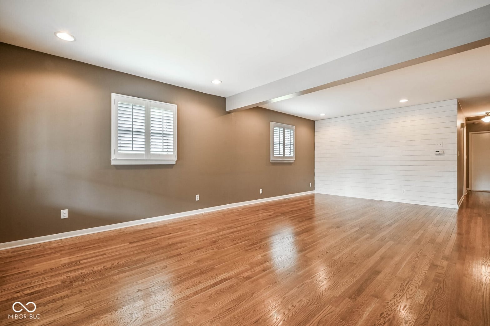 Spacious family room with gleaming hardwood floors and modern finishes.