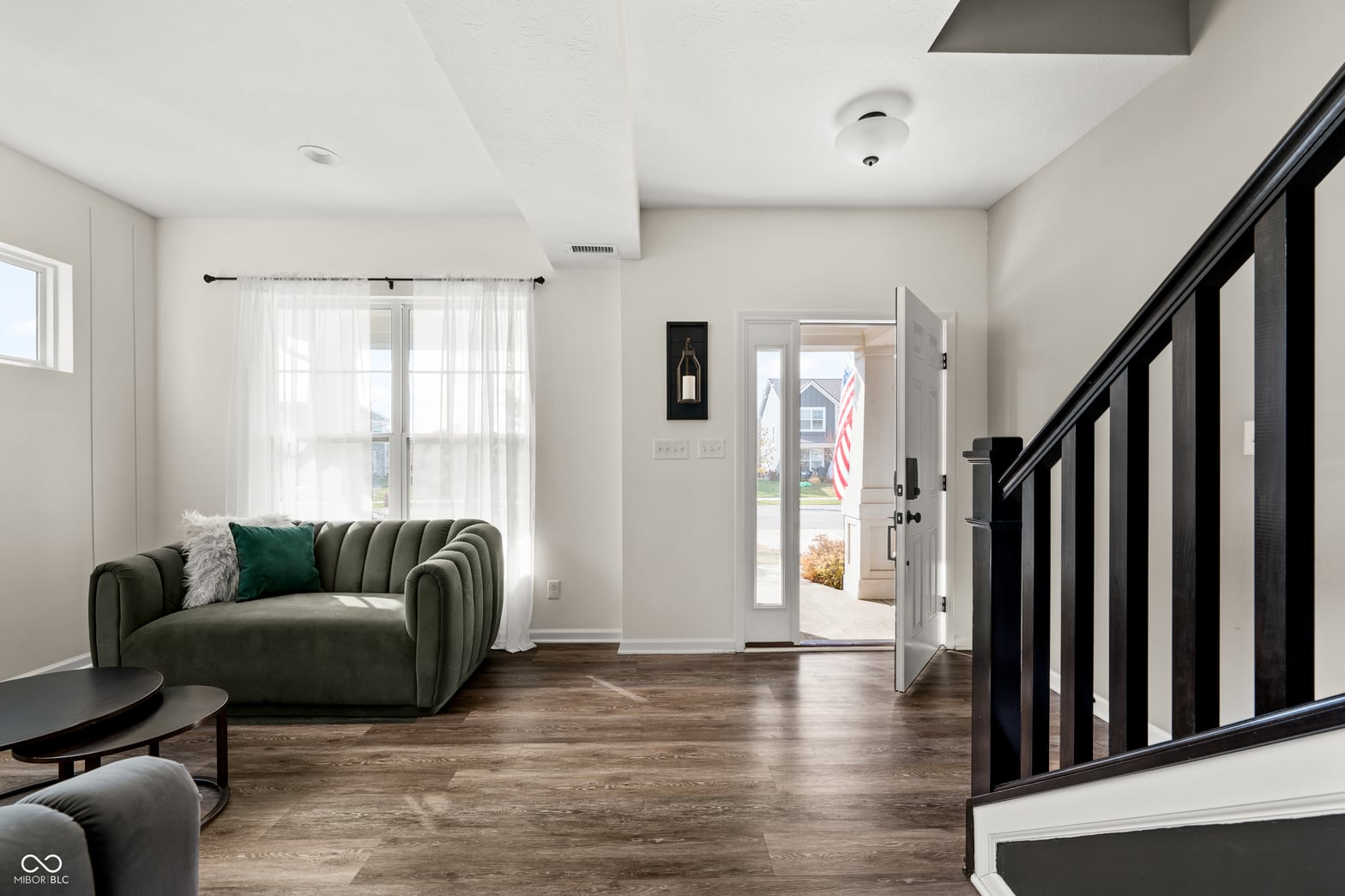 Modern living room with curved sofa and glass entry doors.