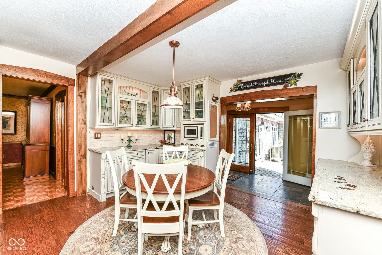 Spacious kitchen with exposed beams and glass-front cabinetry.