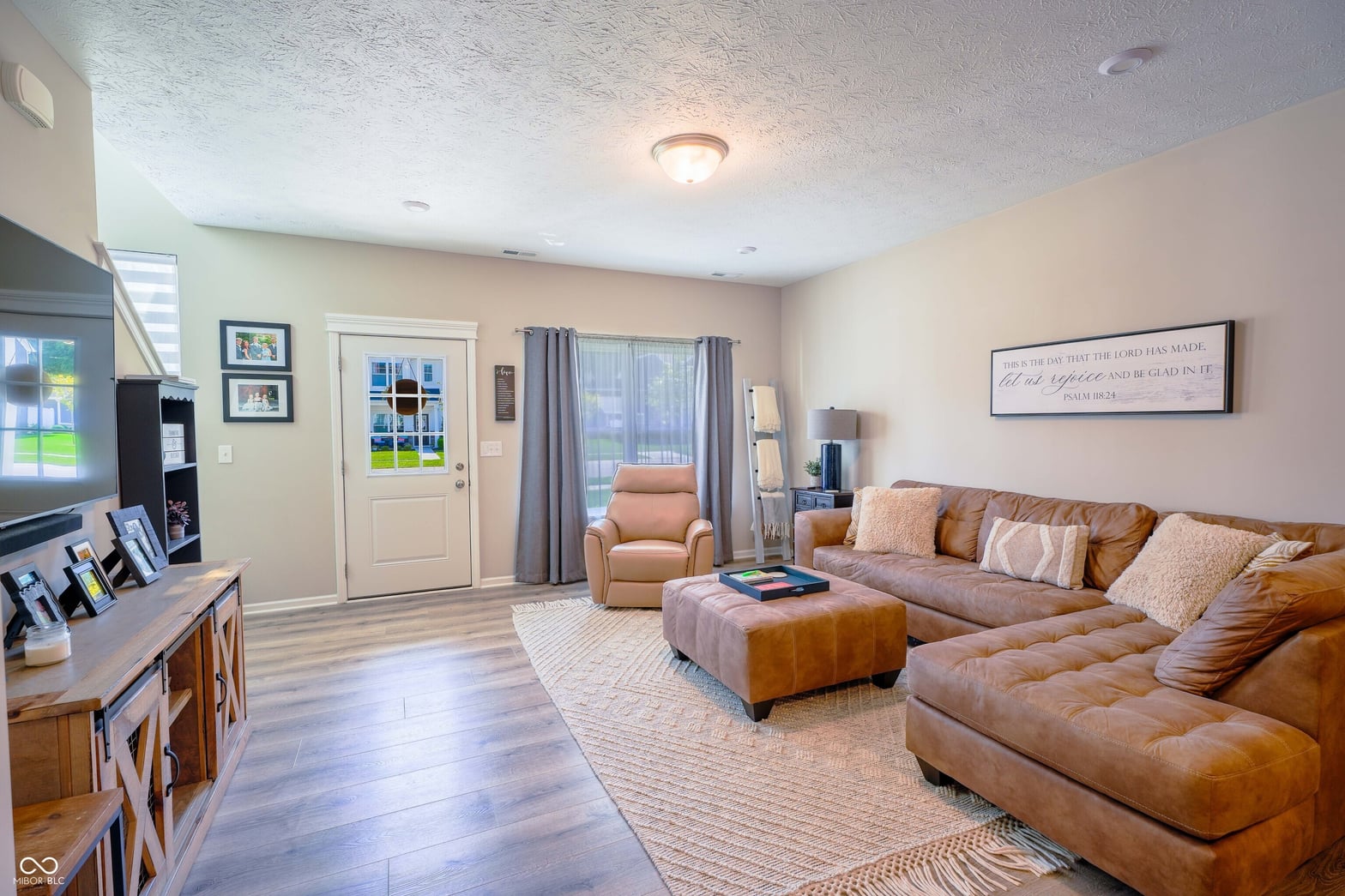 Spacious family room with luxury leather sectional and natural light.