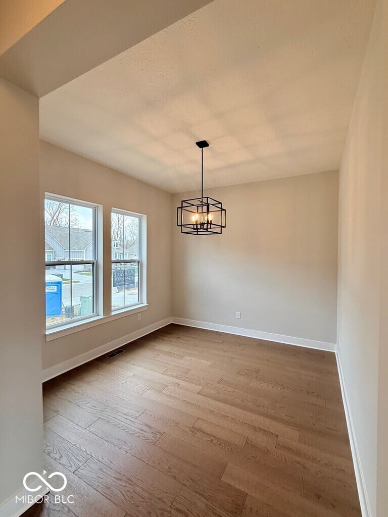 Bright dining space with vaulted ceilings and large windows.