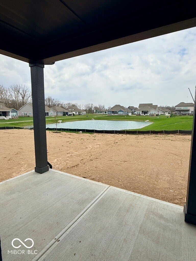 Covered patio overlooks private pond and open yard.