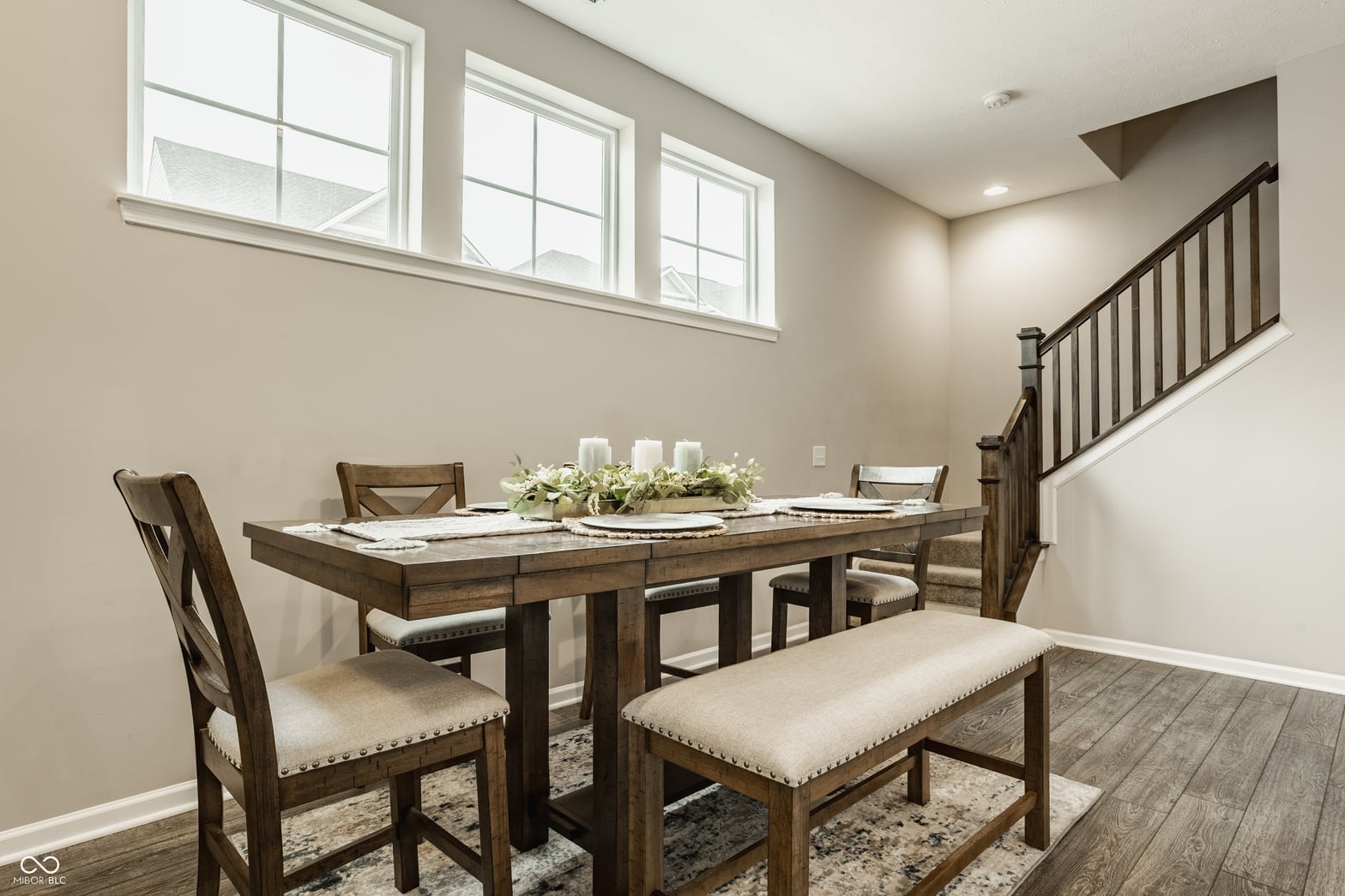 Bright dining room with high windows and wood finishes.