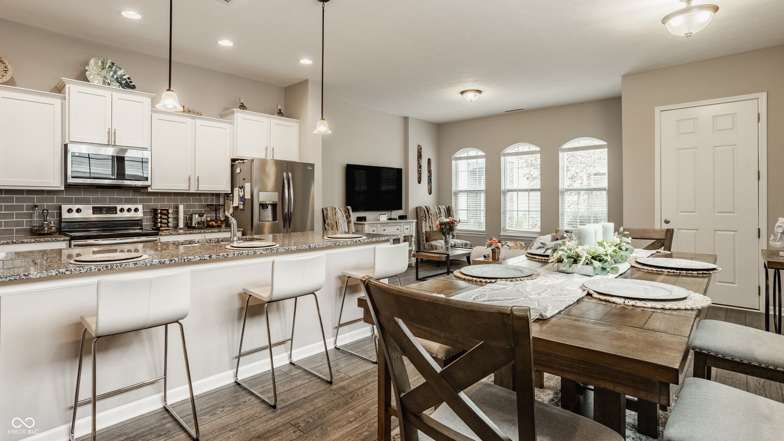 Bright open kitchen with granite island and stainless appliances.