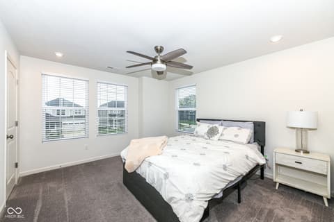 Primary bedroom at 15104 Downham Drive, Fishers, IN — Bright primary bedroom with plantation shutters and views.