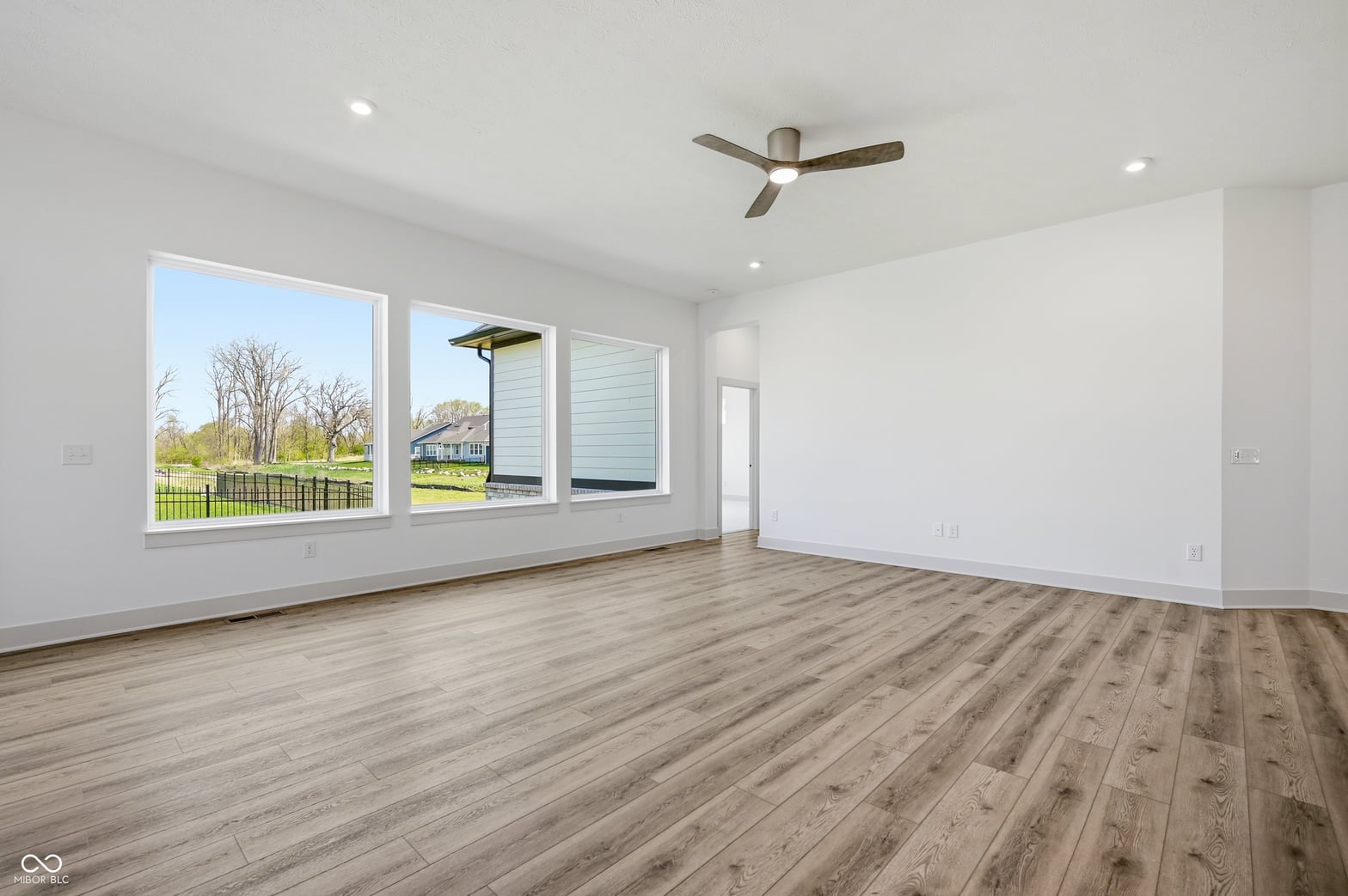 Bright modern family room with expansive windows and hardwood floors.