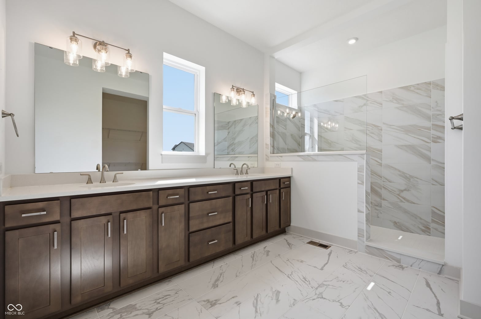 Luxurious primary bath with marble finishes and dual vanity.