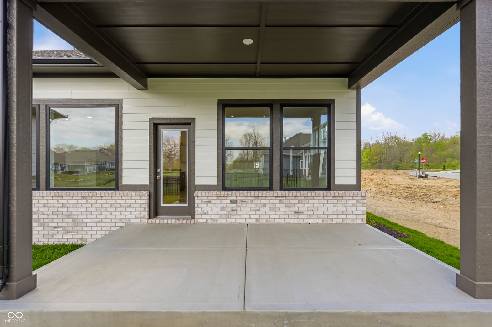 Modern covered patio with expansive windows and views.