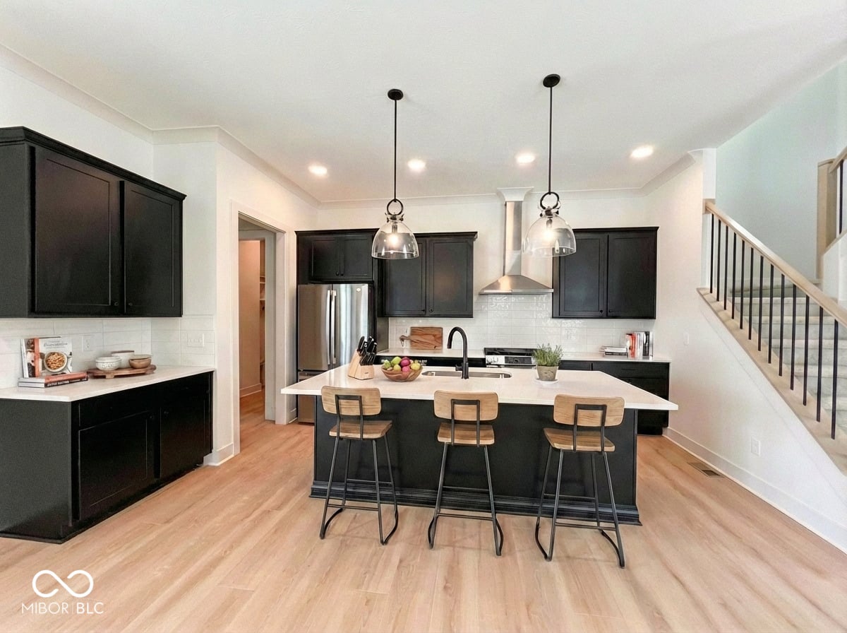 Modern kitchen with black cabinetry and white quartz island.