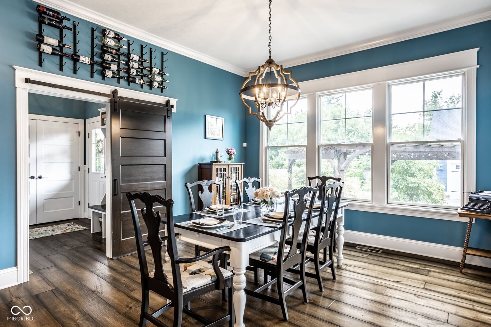 Bright dining room with elegant teal walls and natural light.