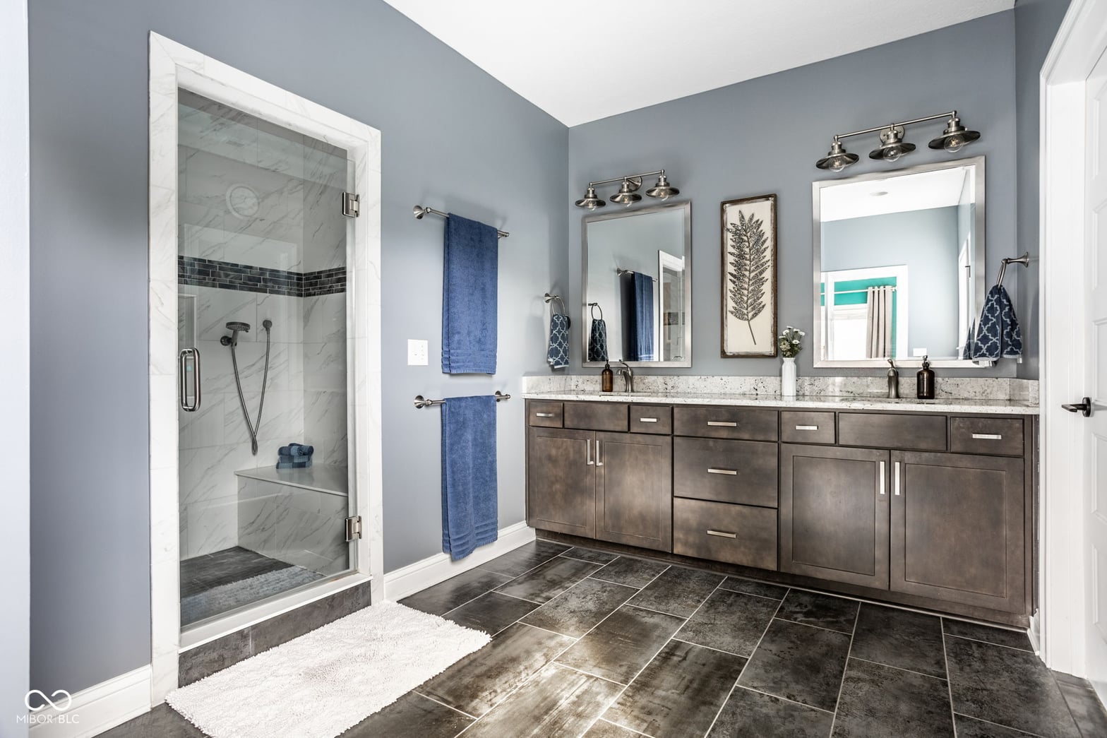 Luxury primary bath with frameless shower and double vanity.