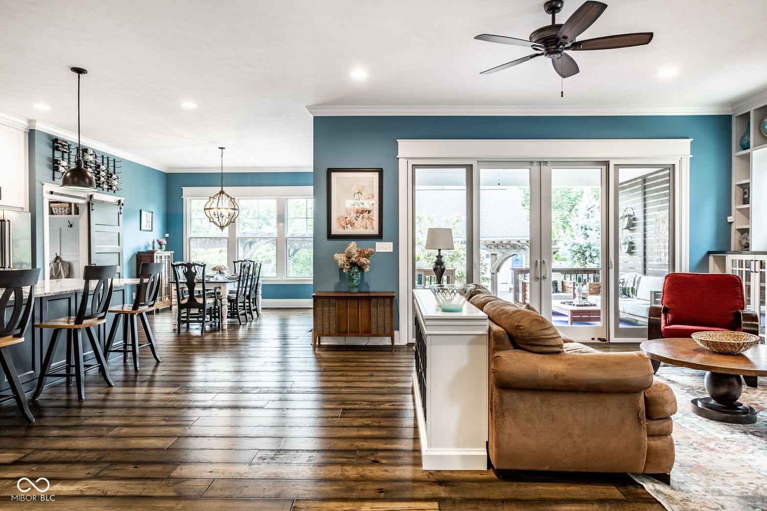 Bright open-concept living with teal accents and patio access.