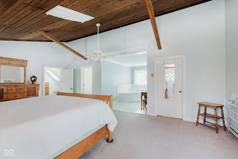 Primary bedroom at 140 Wiley Street, Cicero, IN — Spacious primary suite with exposed beams and ensuite bath.