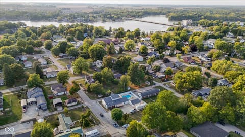 Aerial view at 140 Wiley Street, Cicero, IN — Waterfront neighborhood with mature trees and river access.