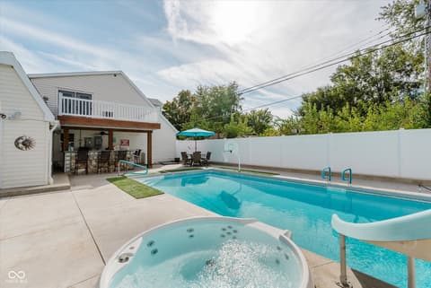 Outdoor living area at 140 Wiley Street, Cicero, IN — Resort-style backyard with pool, hot tub, and covered patio.