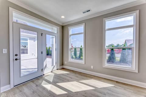 Family room at 14832 Higgins Drive, Westfield, IN — Bright open space with French doors and expansive windows.