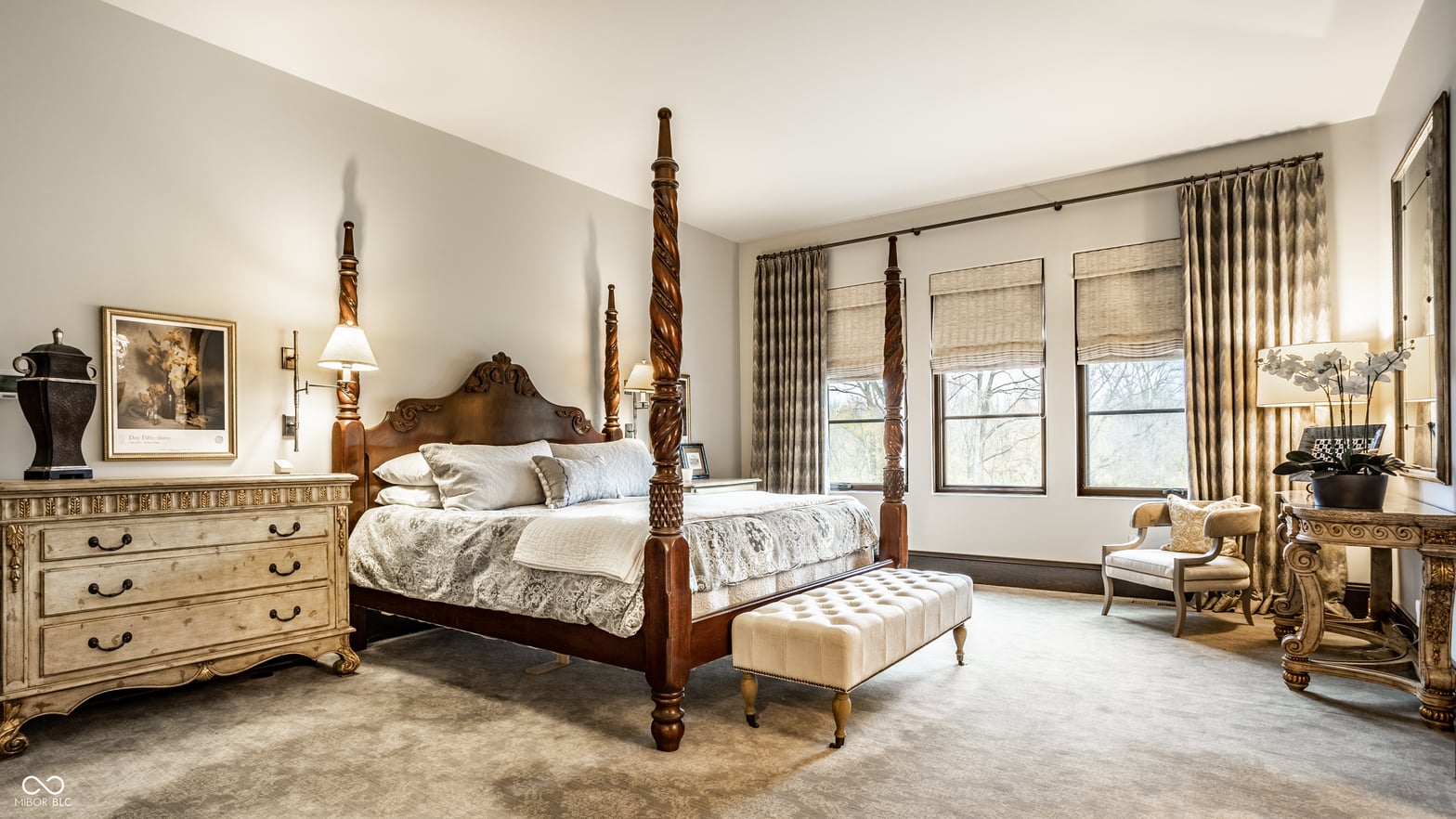 Luxurious traditional primary bedroom with four-poster bed.