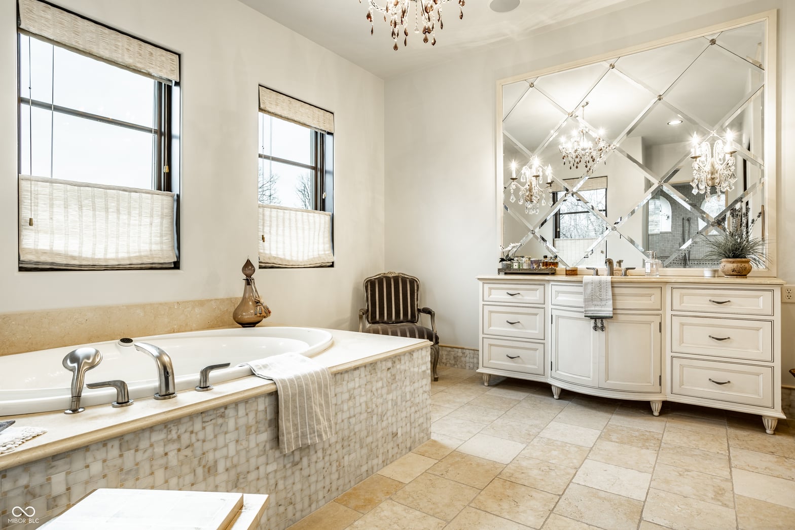 Luxurious primary bath with soaking tub and marble finishes.