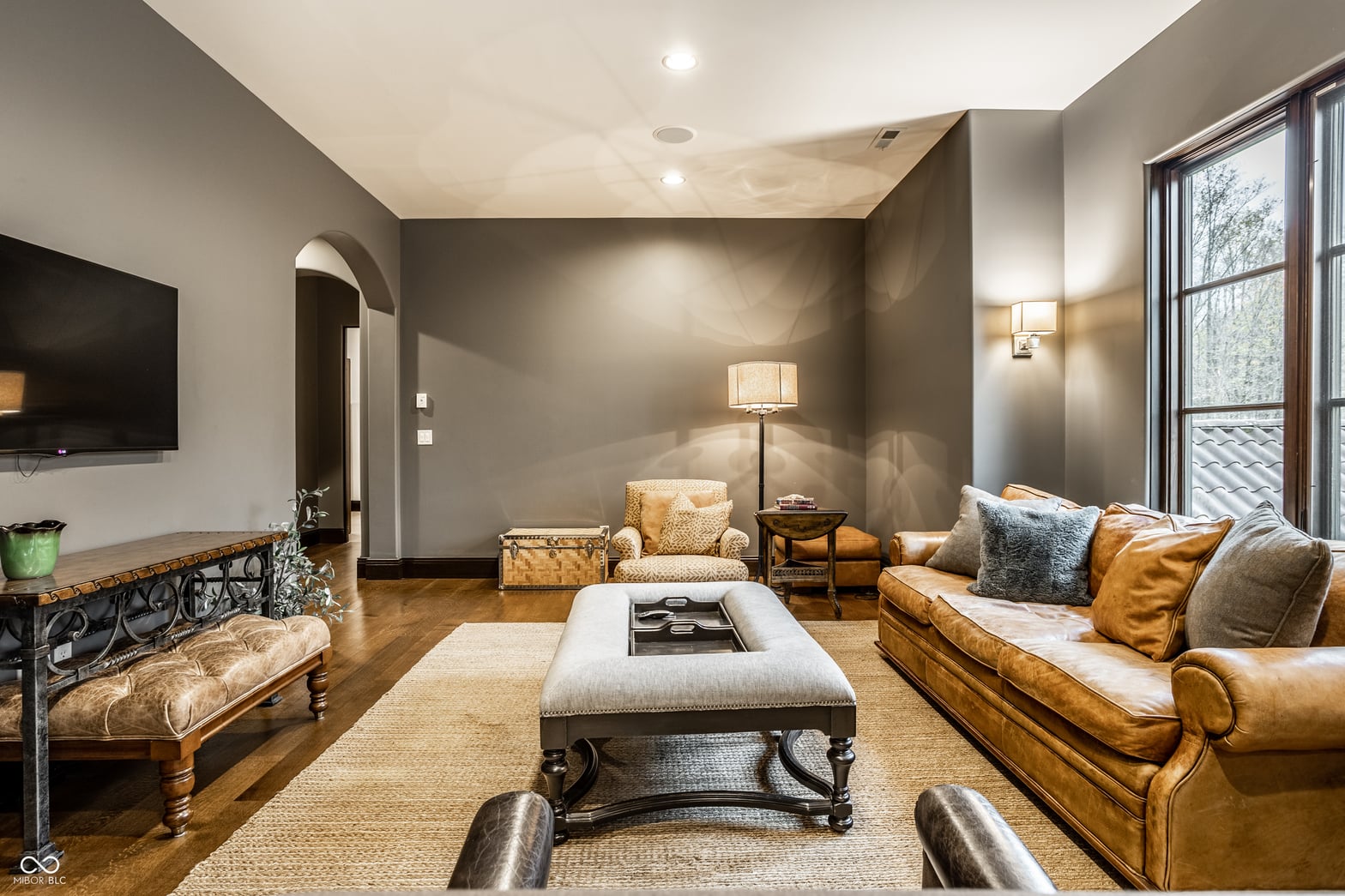 Sophisticated family room with luxury leather seating and natural light.