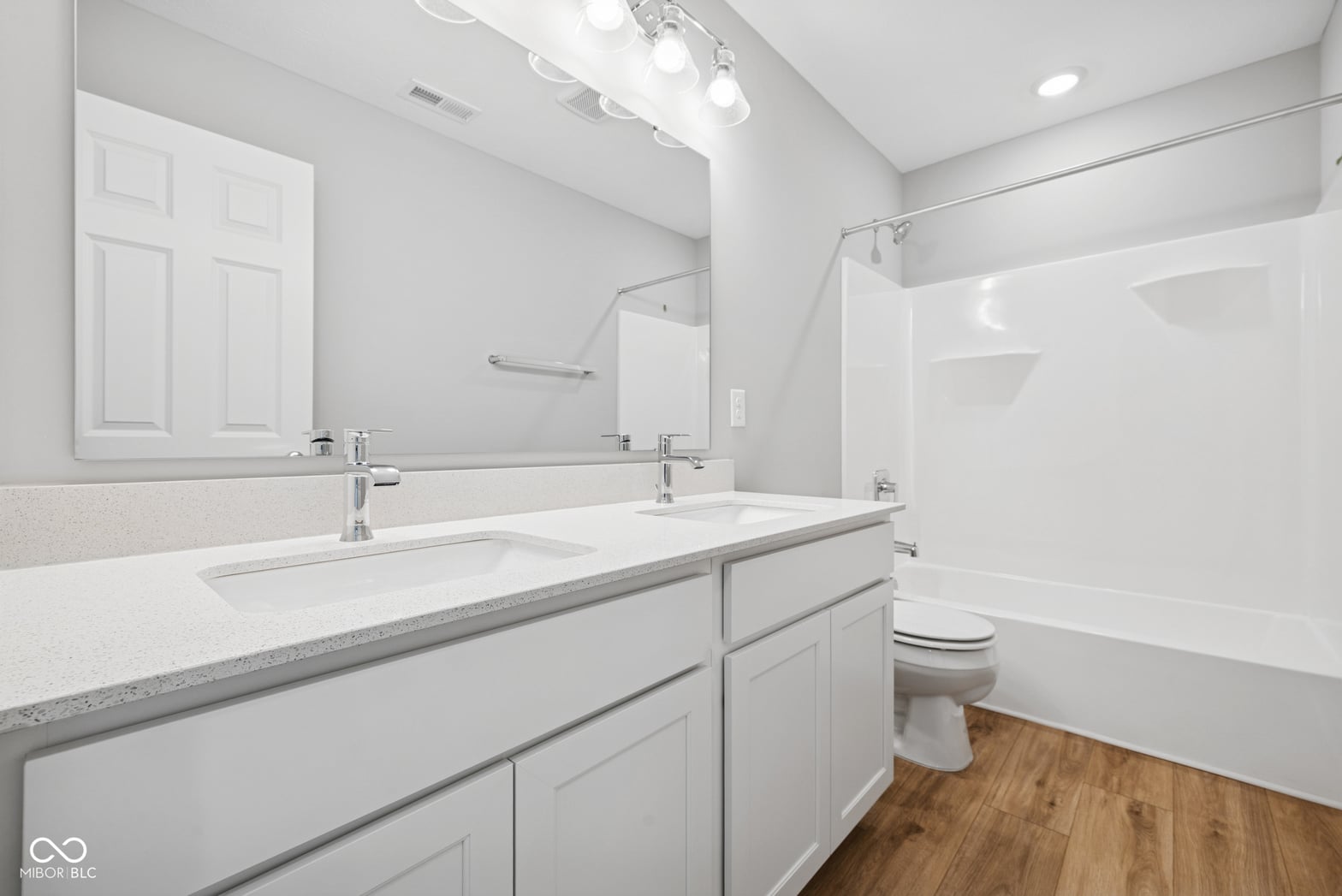 Luxurious primary bath with dual vanity and spa tub.
