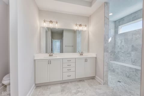 Primary bathroom at 16098 Quarter Pole Lane, Westfield, IN — Luxurious primary bath with dual vanity and marble finishes.