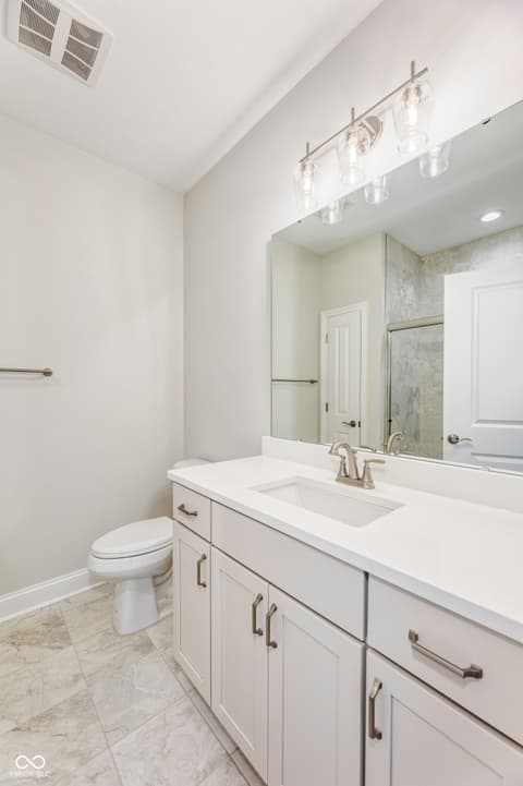 Primary bathroom at 16098 Quarter Pole Lane, Westfield, IN — Bright, modern bathroom with pristine white cabinetry.