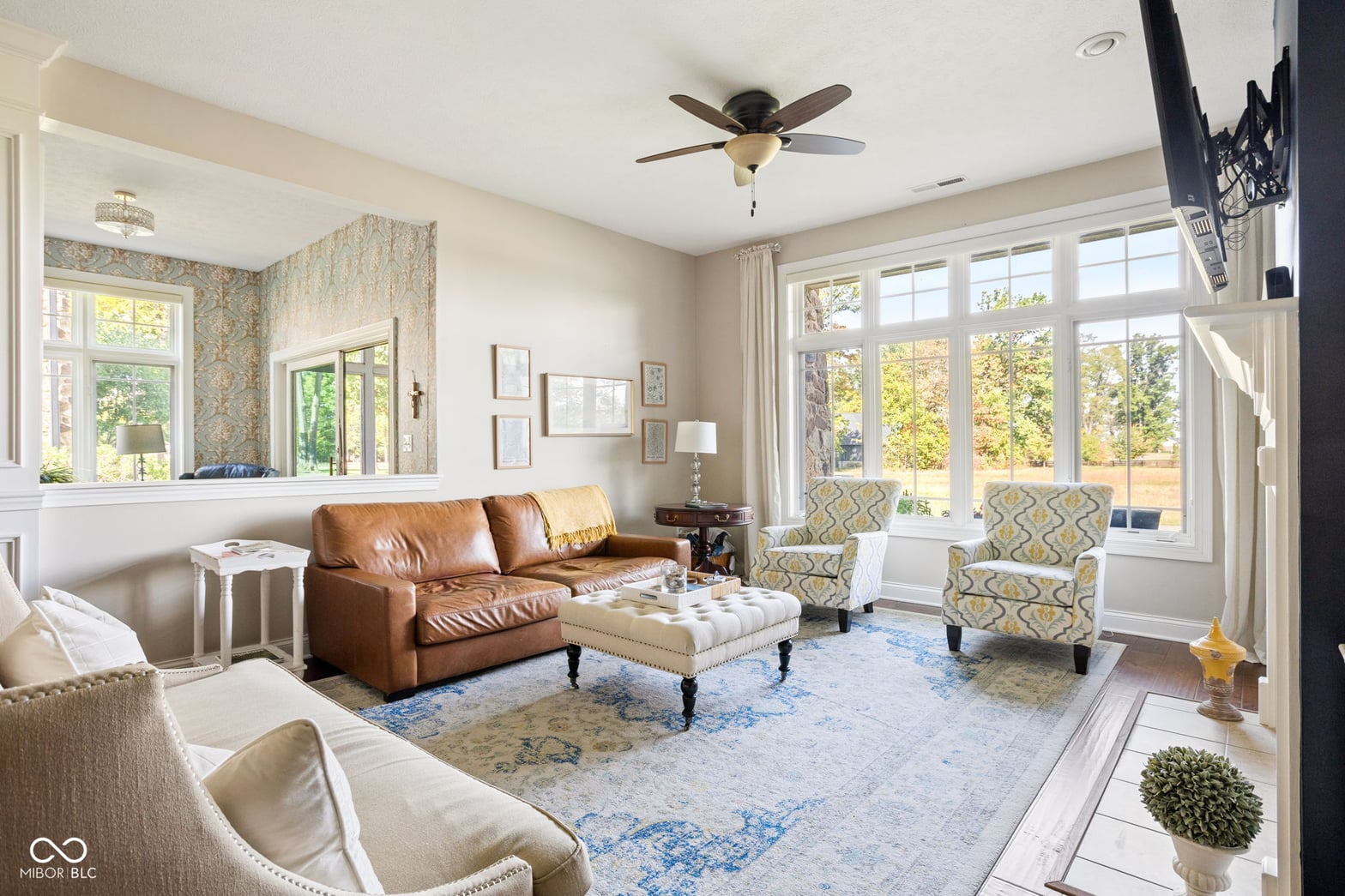 Bright living room with abundant windows and quality furnishings.