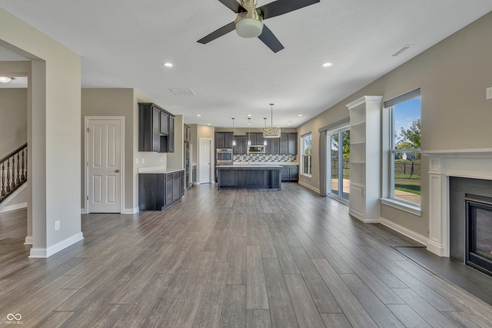Spacious kitchen with island and fireplace overlooking backyard.