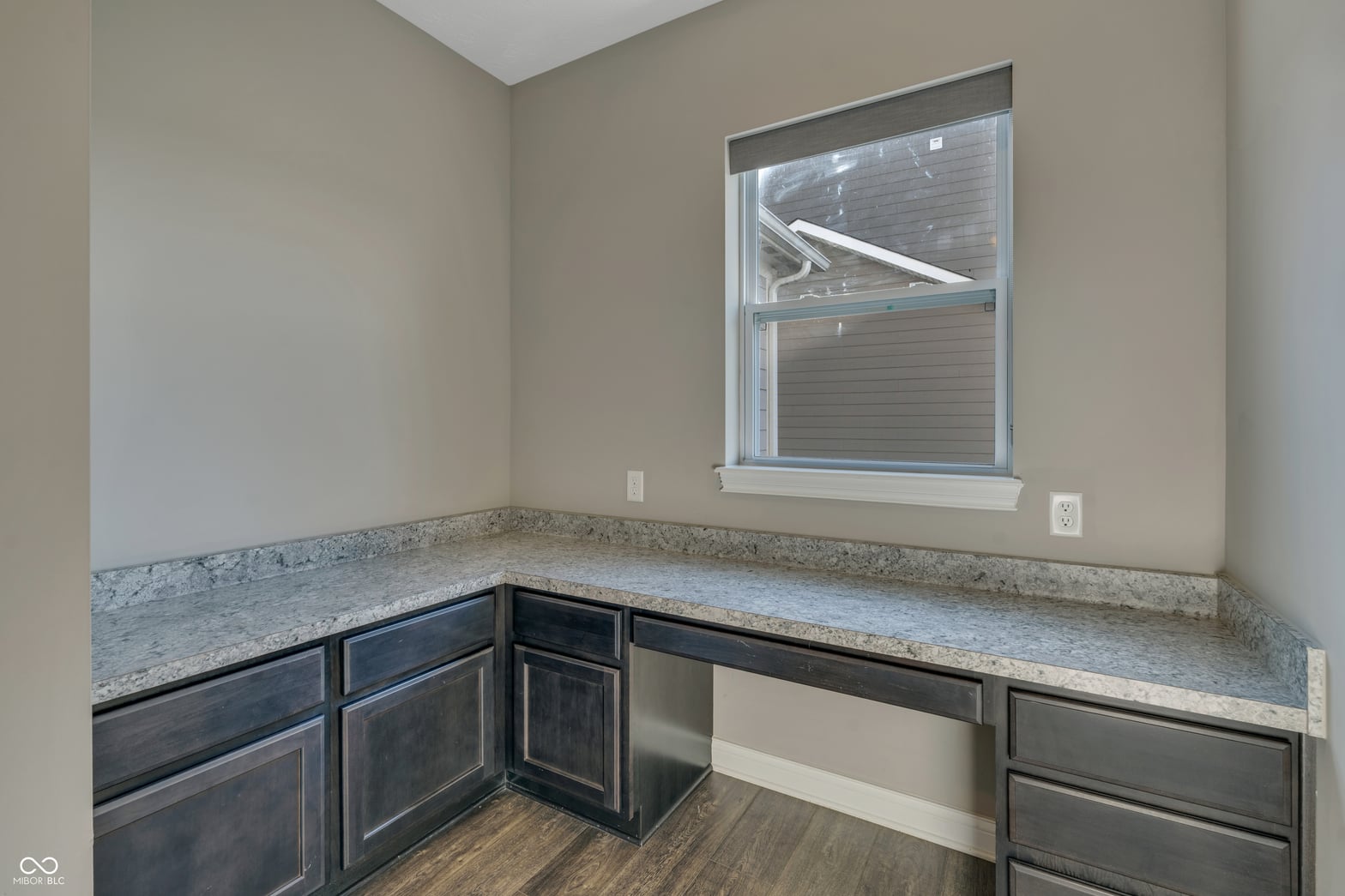 Spacious built-in office with granite counters and storage.