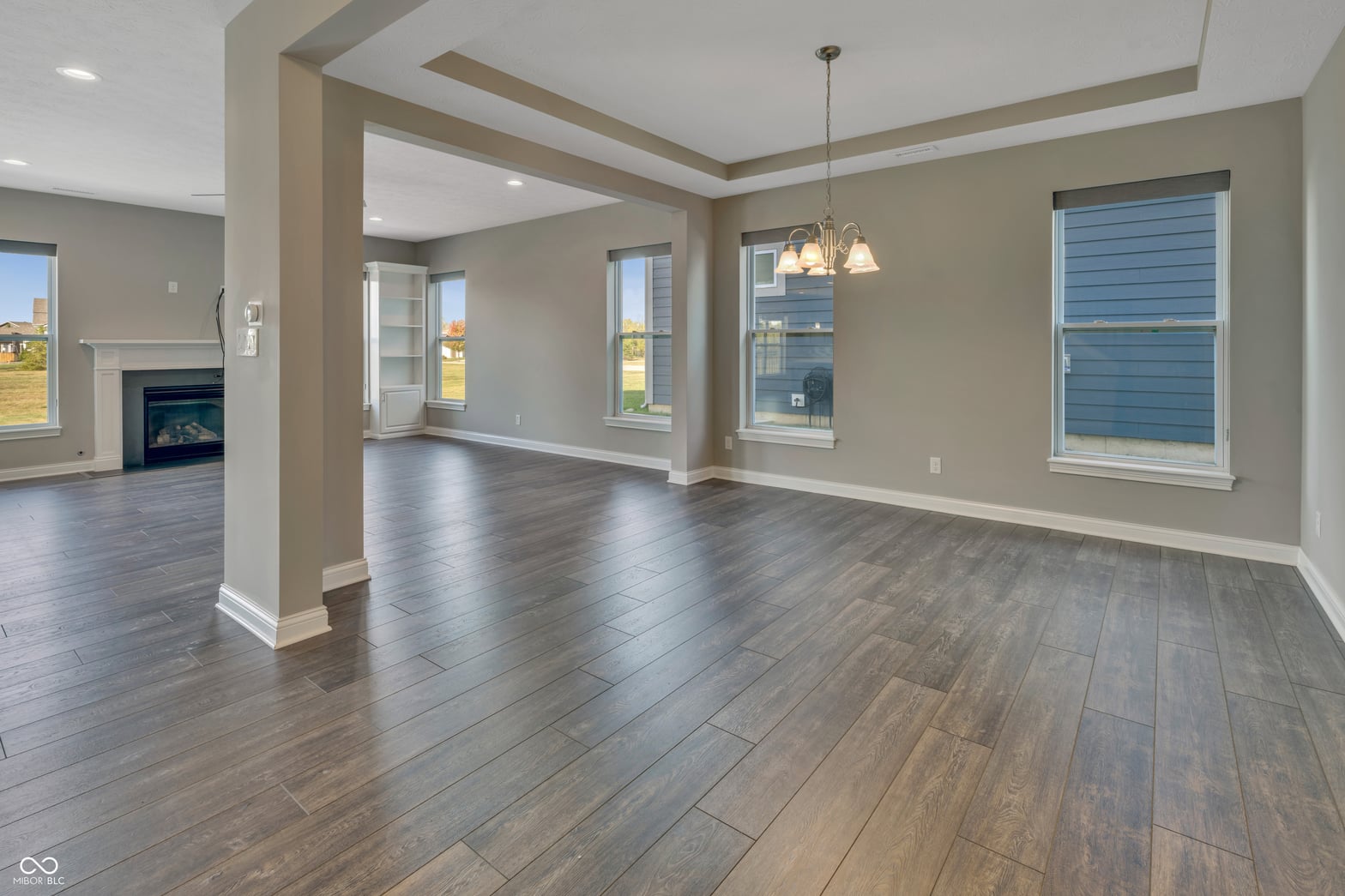 Bright open-concept family room with coffered ceilings and hardwood floors.