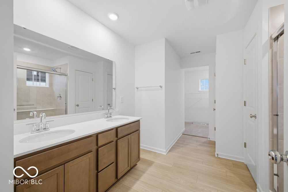 Spacious primary bath with double vanity and walk-in shower.