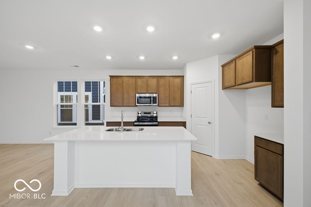 Modern kitchen with oak cabinetry and white quartz island.