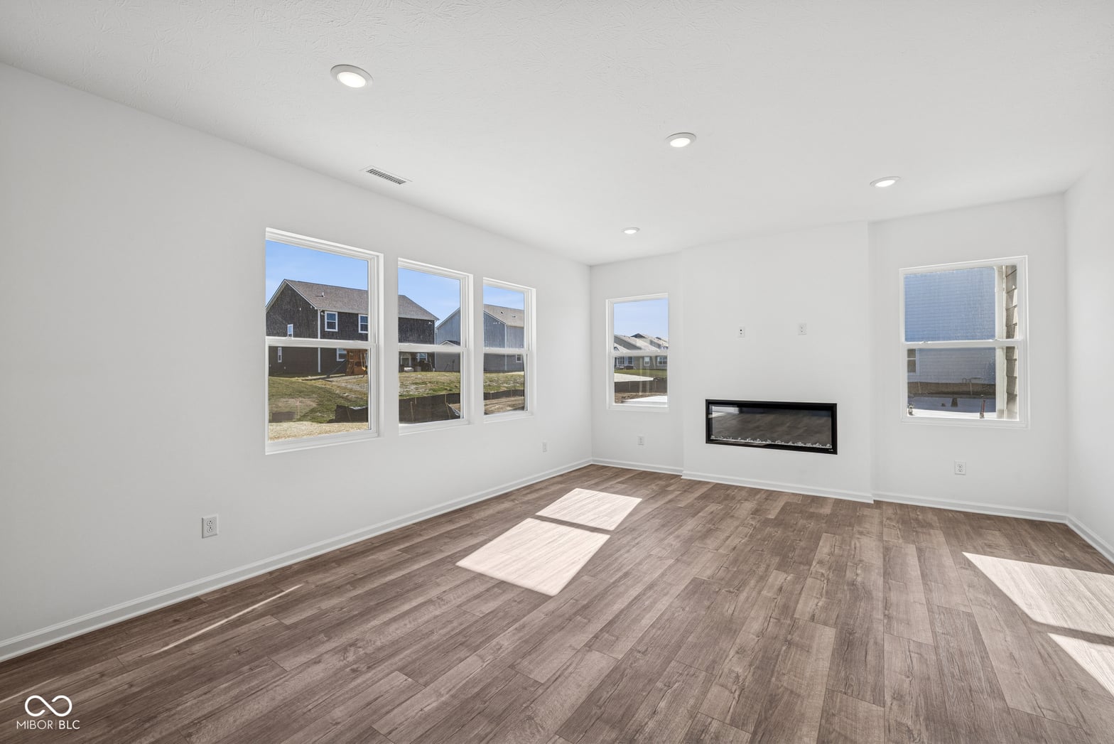 Bright contemporary living room with linear fireplace and hardwoods.