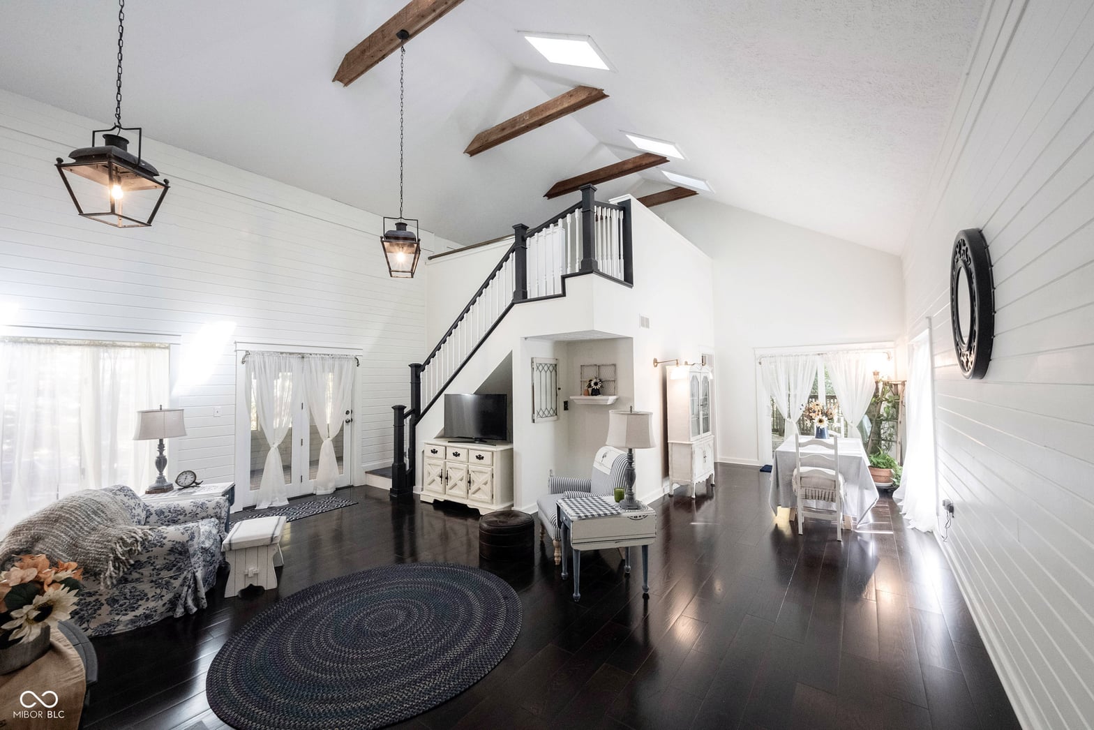 Bright lofted primary suite with skylights and exposed beams.