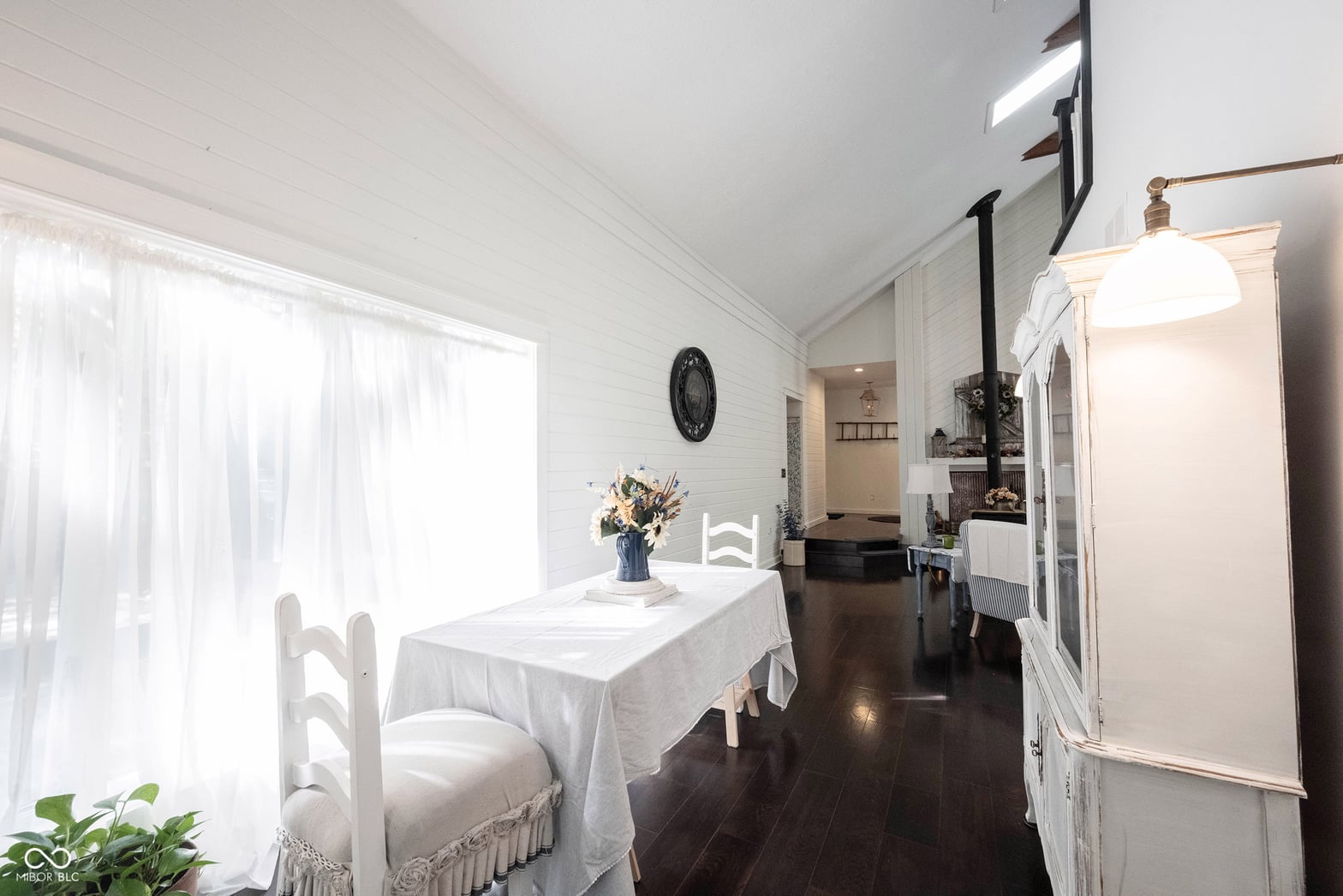 Bright, airy farmhouse dining with hardwood floors and natural light.