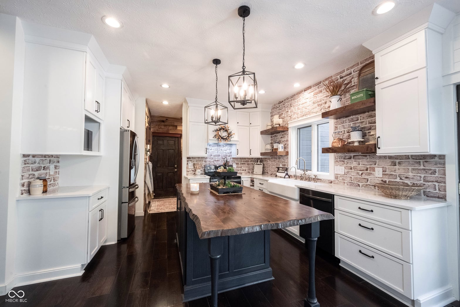 Charming farmhouse kitchen with brick and white cabinetry.