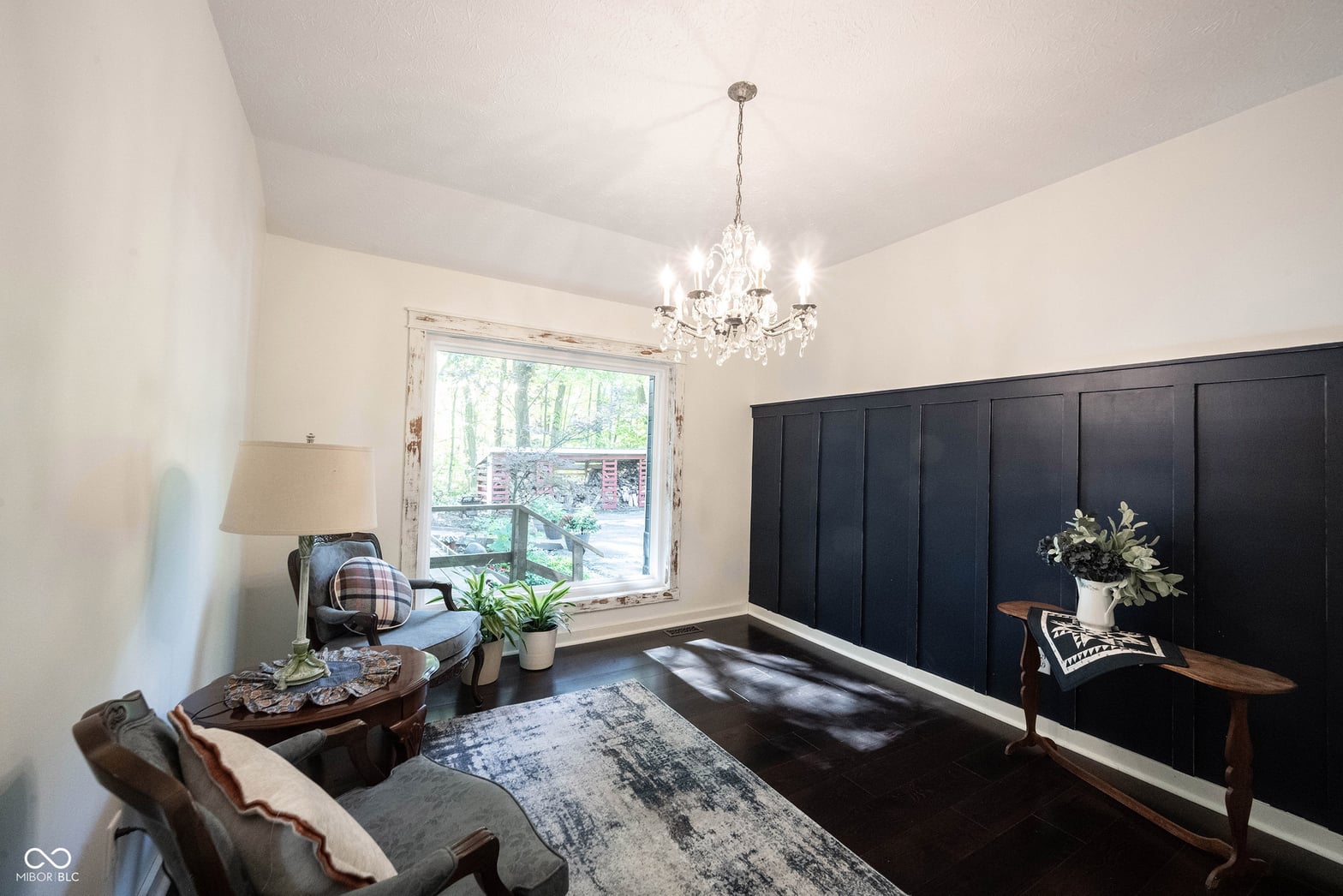 Elegant living room with black shiplap accent wall and chandelier.