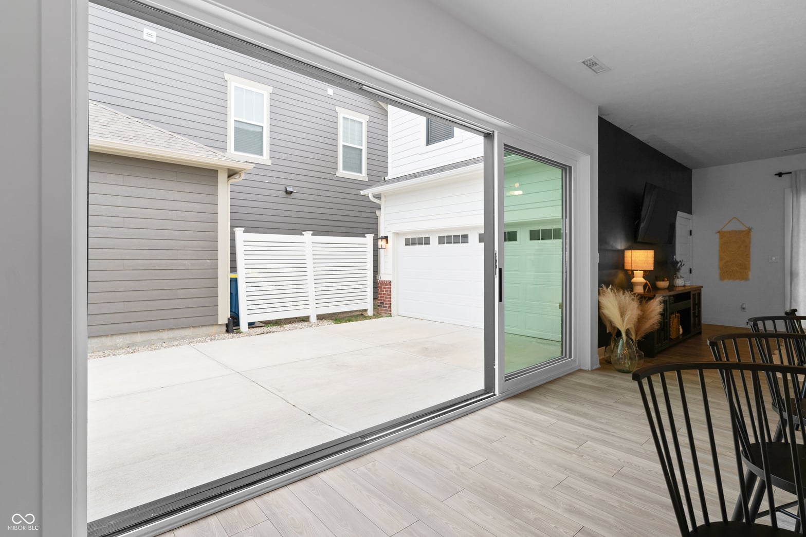 Expansive sliding doors open to modern patio space.