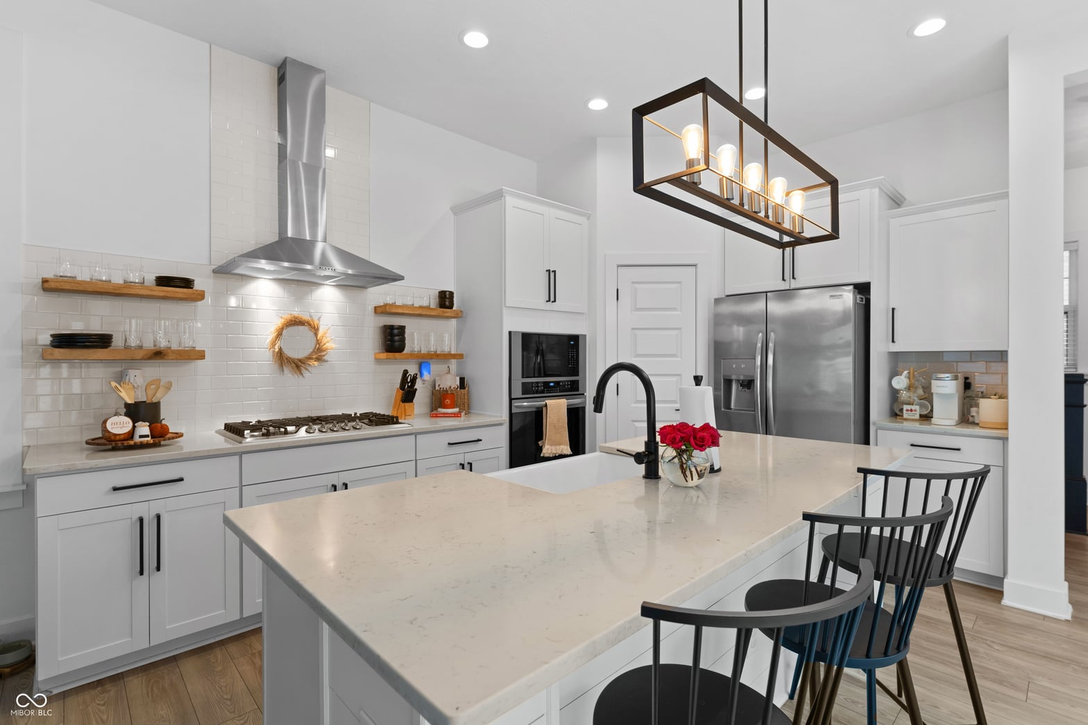 Modern kitchen with large island and stainless steel appliances.