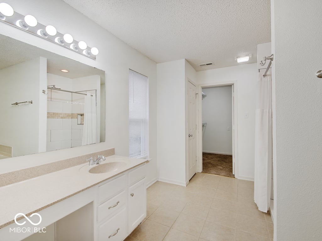Spacious primary bath with dual vanity and modern shower.