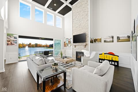 Living room at 4301 Stone Lake Drive, Zionsville, IN — Waterfront living room with soaring ceilings and fireplace.